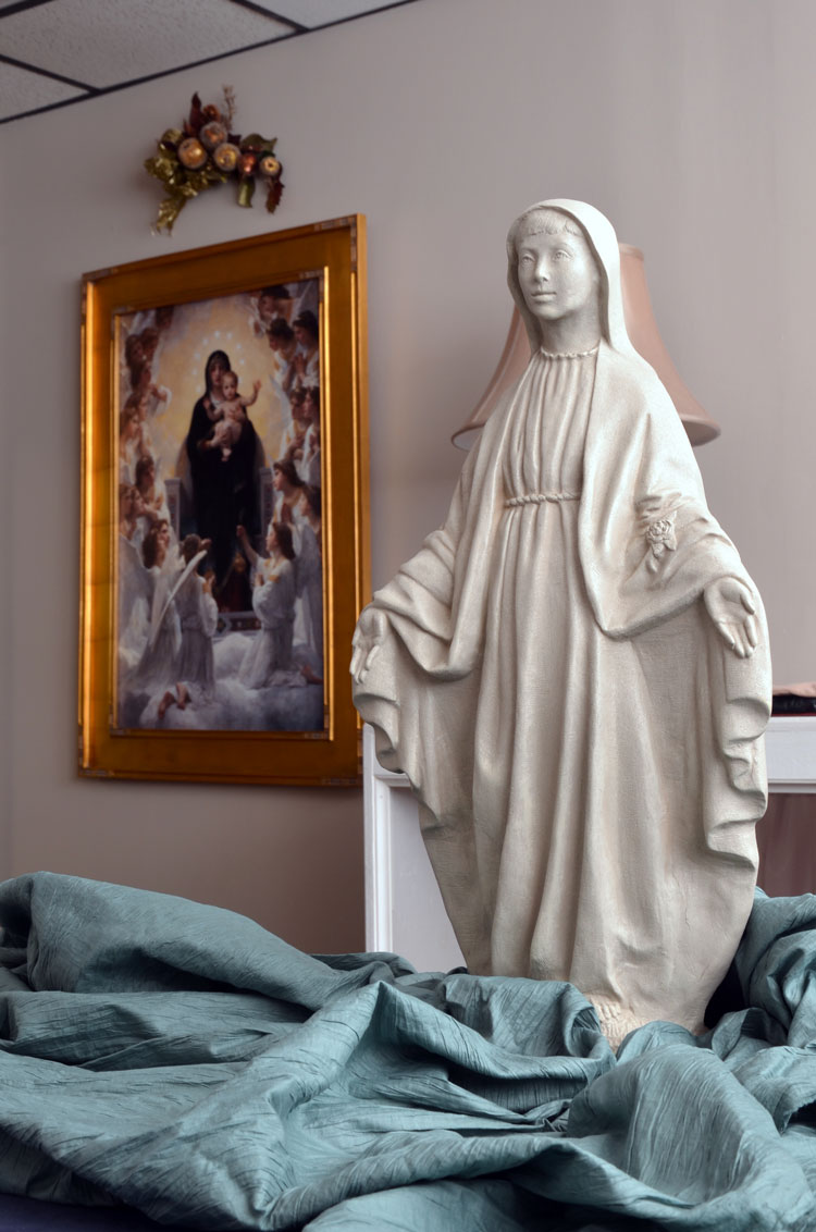 Madonna statue with painting in the background insiide Karen's consultation room